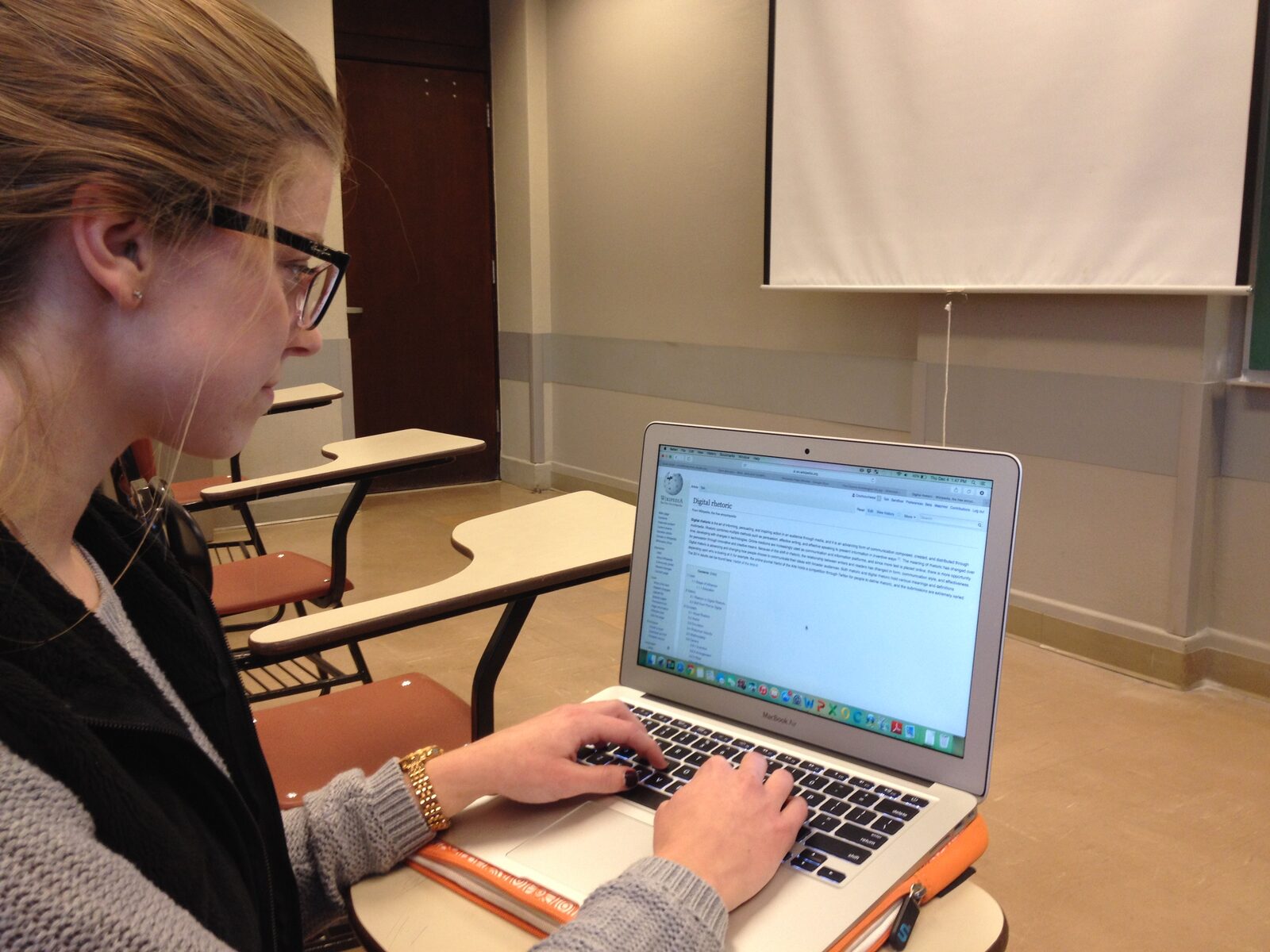 A student in a classroom using a laptop computer
